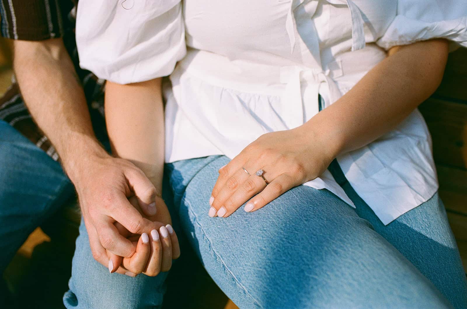 couple holds hands on patio at mrs robinson during little italy engagement session in toronto