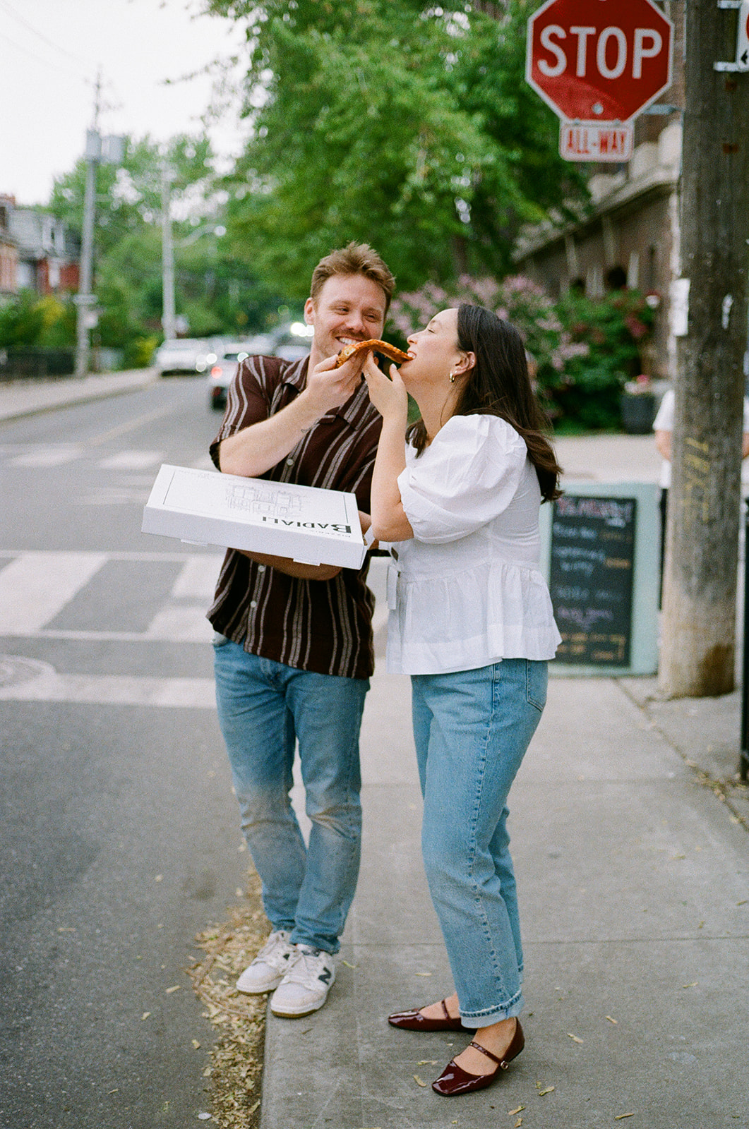 Documentary-style film photo of engaged couple outside Badiali’s Pizza