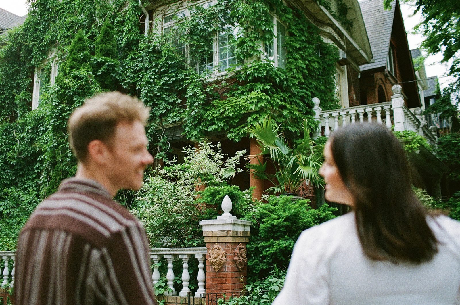 Authentic film engagement photo capturing connection and movement in Little Italy