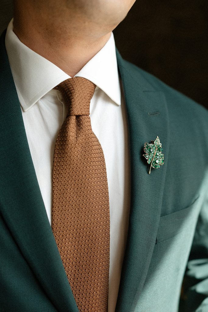 Groom lapel brooch on green suit at Toronto wedding The Drake Hotel