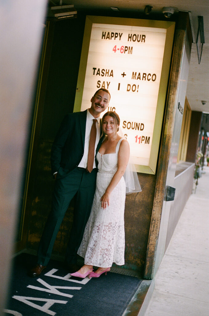 couple poses in front of the marquis at the Drake hotel toronto for their wedding