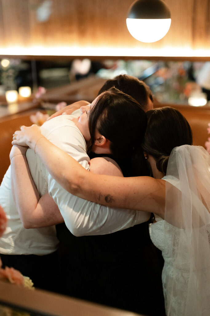 couple hugging a friend at their drake hotel wedding
